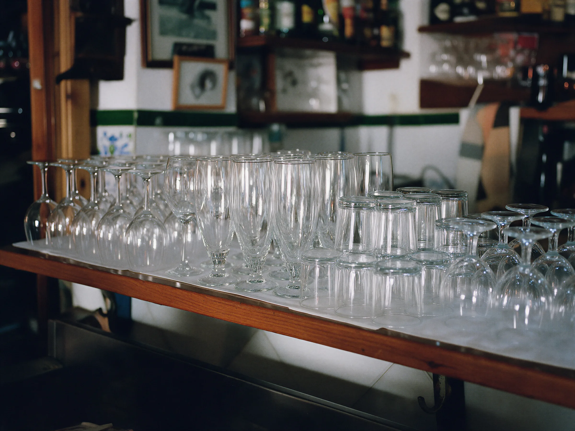 Copas, vasos de caña y vasos bajos limpios en una estantería de barra